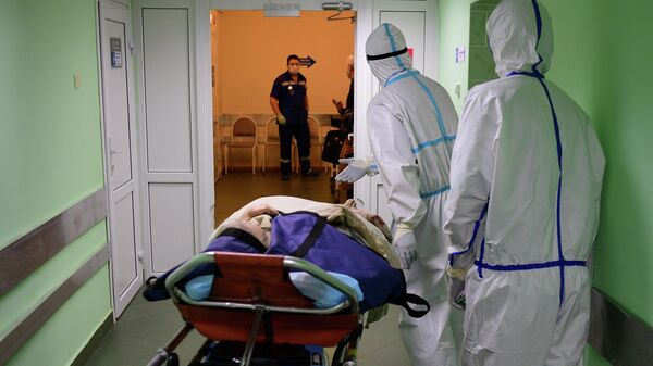 Пациент и медицинские работники в городской клинической больнице имени В. В. Виноградова, переоснащенной для лечения пациентов с COVID-19