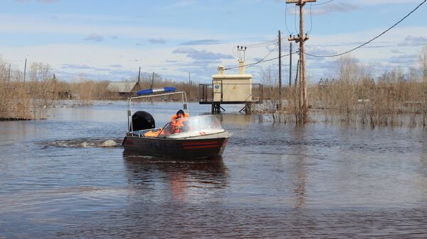 Сотрудник МЧС РФ на катере в подтопленном участке у поселка Кангалассы, Якутия