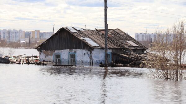 Подтопленный дом в поселке Кангалассы в результате остановки ледохода на реке Лена
