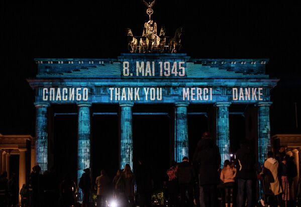 Надпись Спасибо, спроецированная на четырех языках - русском, английском, французском и немецком, на Бранденбургских воротах в Берлине 