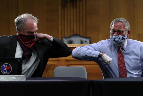 Сенаторы США Ричард Бёрр и Тим Кейн здороваются локтями в Вашингтоне, США 