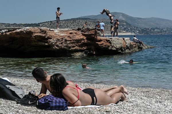 Отдыхающие на пляже в пригороде Афин