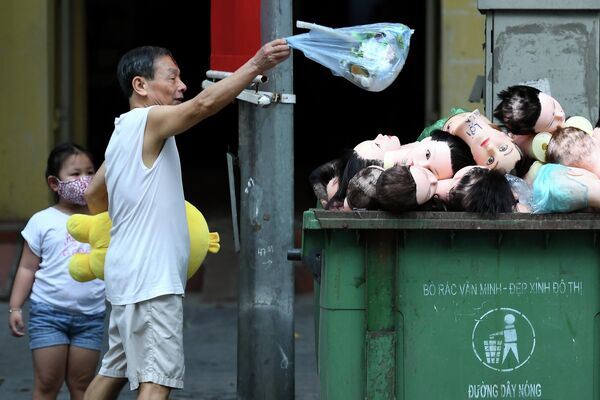 Человек бросает мусор в мусорное ведро в Ханое