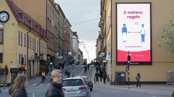 Плакат с напоминанием о социальной дистанции на фасаде дома в Стокгольме, Швеция 