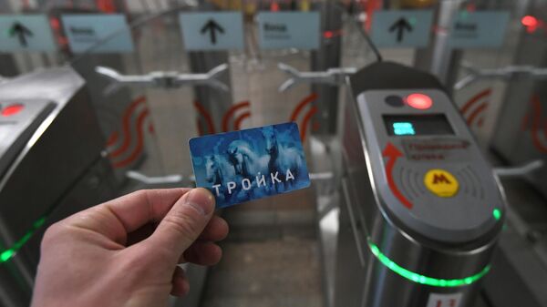 Пассажир проходит с картой Тройка через турникет на станции метро