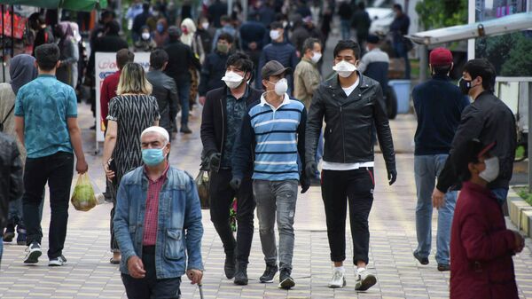 Прохожие в защитных масках на одной из улиц в Душанбе
