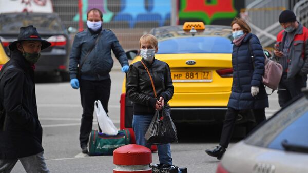 Прохожие в медицинских масках недалеко от здания Курского вокзала в Москве во время пандемии коронавируса