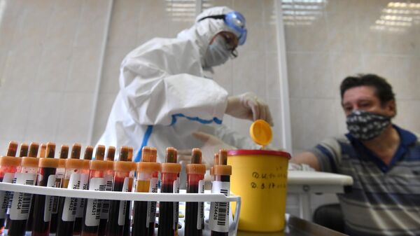 Медицинский работник проводит забор крови на наличие антител к COVID-19 в городской поликлинике Москвы