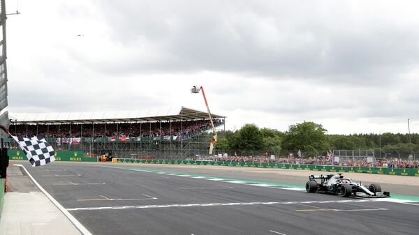 Пилот Мерседеса Льюис Хэмилтон пересекает финишную линию на Гран-при Великобритании Формулы-1