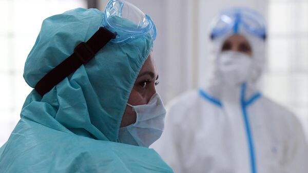 Медицинские работники в защитных костюмах в городской поликлинике, где начали брать анализы на наличие антител к COVID-19  Москвы