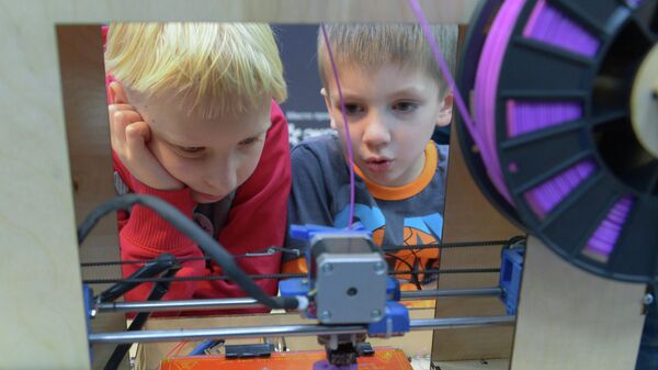 Дети наблюдают за работой 3D-принтера