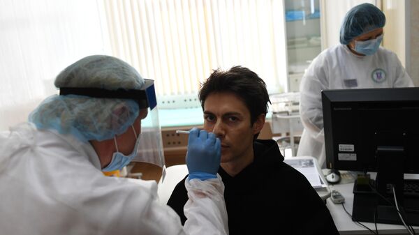 Мужчина во время взятия мазка для анализа на коронавирус COVID-19 в одной городских поликлиник в Москве