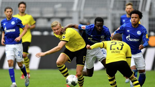 Dortmund's Norwegian forward Erling Braut Haaland (Center L) vies for the ball with Schalke's Senegalese defender Salif Sane during the German first division Bundesliga football match BVB Borussia Dortmund v Schalke 04 on May 16, 2020 in Dortmund, western Germany as the season resumed following a two-month absence due to the novel coronavirus COVID-19 pandemic. (Photo by Martin Meissner / POOL / AFP) / DFL REGULATIONS PROHIBIT ANY USE OF PHOTOGRAPHS AS IMAGE SEQUENCES AND/OR QUASI-VIDEO