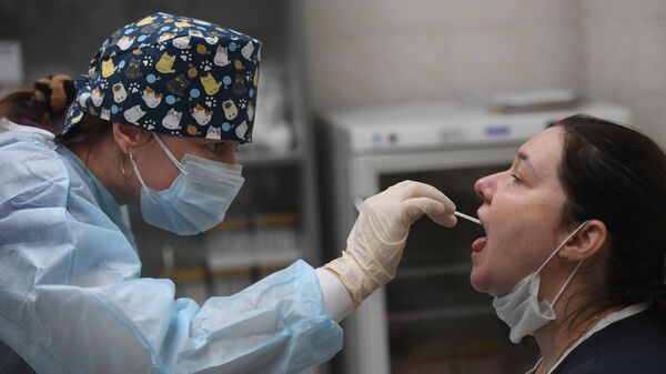 Медсестра во время взятия мазка на коронавирус COVID-19 