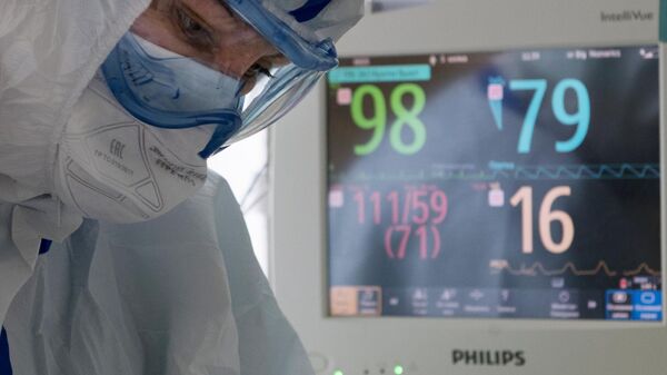 Медицинский работник возле кровати пациента в отделении реанимации и интенсивной терапии госпиталя COVID-19 в ГКБ No1 имени Н.И. Пирогова в Москве