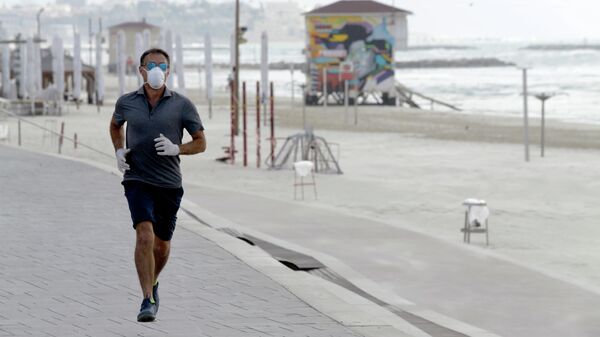 Мужчина во время пробежки на набережной в Тель-Авиве