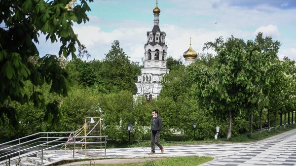 Прохожий у храма Ильи Пророка в Черкизове в Москве  во время режима самоизоляции жителей
