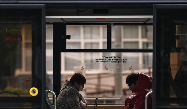 Пассажиры в защитных масках в салоне трамвая во время режима самоизоляции жителей