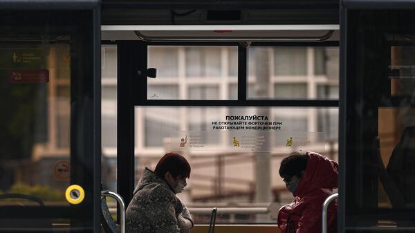 Пассажиры в защитных масках в салоне трамвая во время режима самоизоляции жителей