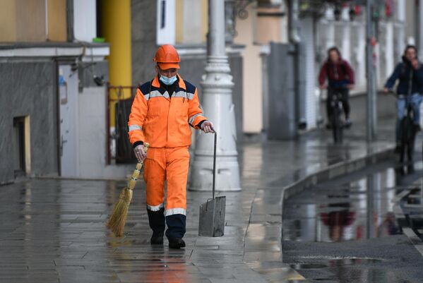 Сотрудник коммунальной службы убирает улицу в Москве