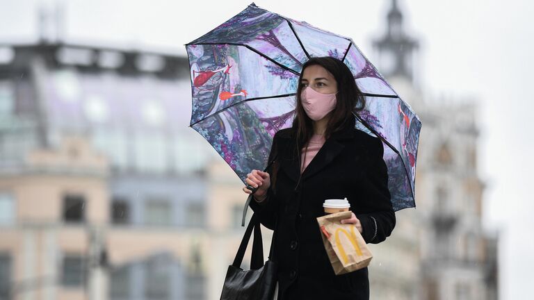 Женщина под зонтом на улице Москвы