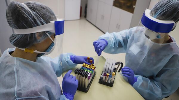 Медицинские работники обрабатывают полученный биоматериал на наличие антител к коровирусу