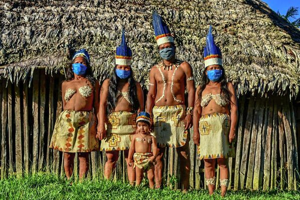 Представители индейского народа группы уитото в медицинских масках в Летисии, Колумбия 