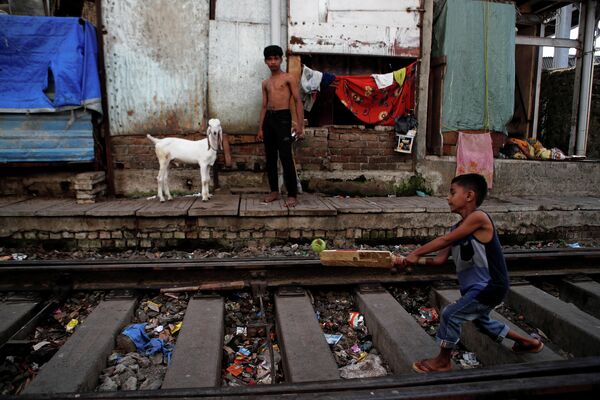 Дети играют на железнодорожных путях в Мумбаи, Индия 
