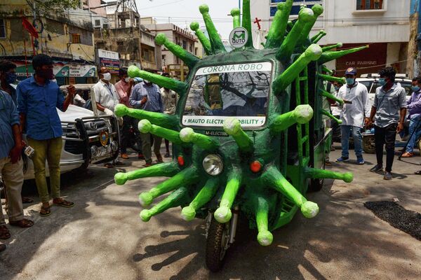 Муниципальный работник передвигается на авторикше, стилизованном под изображение коронавируса в Ченнаи, Индия 