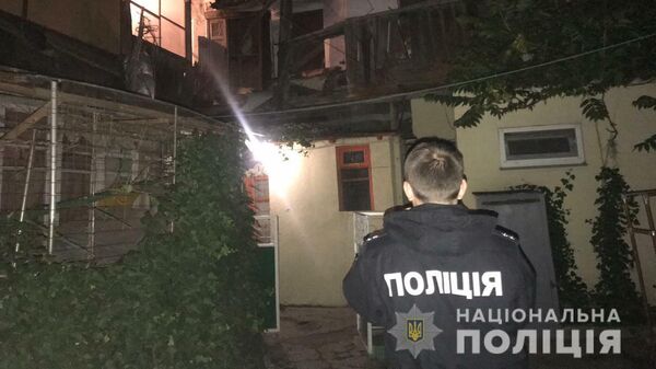 Сотрудник полиции на месте обрушения фасада и крыши двухэтажного жилого дома на улице Среднефонтанская в Одессе