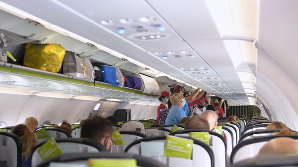 Пассажиры в защитных маска на борту самолета