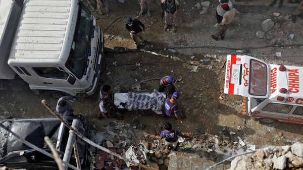 Спасатели на месте крушения пассажирского самолета в жилом районе недалеко от аэропорта в Карачи