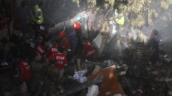 Сотрудники специальных служб извлекают тела погибших на месте крушения пассажирского самолета Airbus A-320 авиакомпании Pakistan International Airlines (PIA) в Карачи