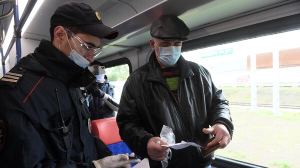 Сотрудник полиции проверяет документы у пассажира в поезде Московских центральных диаметров