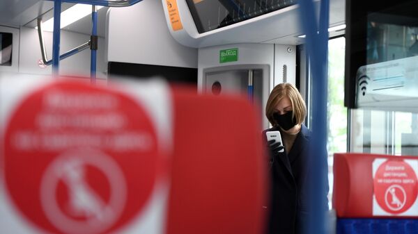 Девушка в защитной маске в поезде Московских центральных диаметров