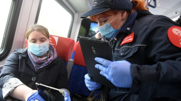 Сотрудница Московского метрополитена проверяет документы у пассажира в поезде Московских центральных диаметров