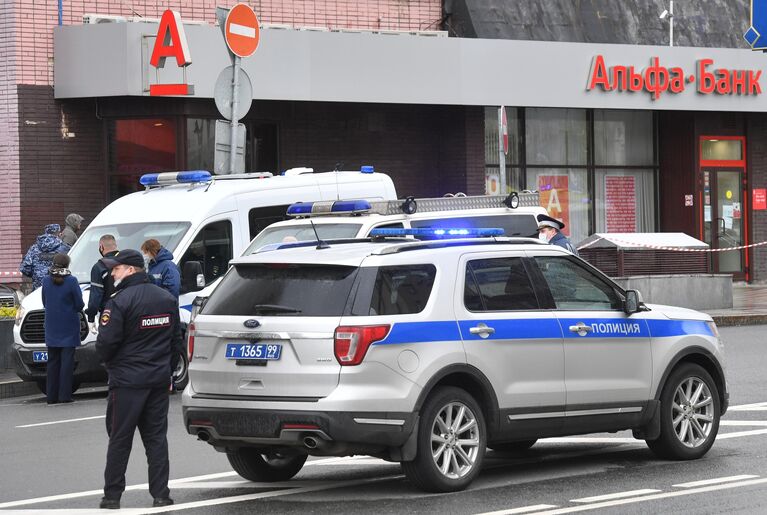 Сотрудники полиции у отделения Альфа-банка в центре Москвы, откуда поступило сообщение, что неизвестный удерживает несколько человек и угрожает взорвать отделение