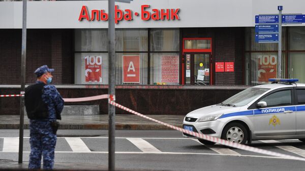 Сотрудник полиции в оцеплении у отделения Альфа-банка в центре Москвы, откуда поступило сообщение, что неизвестный удерживает несколько человек и угрожает взорвать отделение