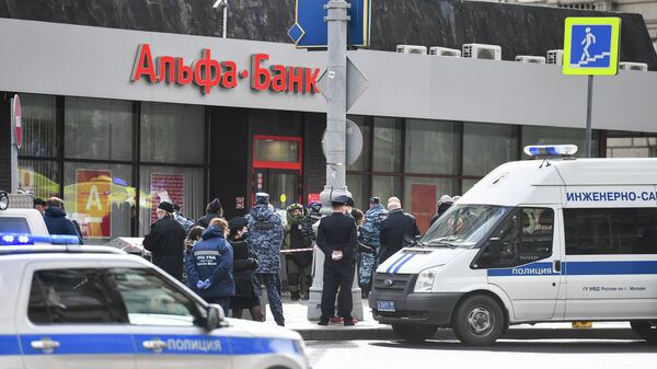 Сотрудники полиции у отделения Альфа-банка в центре Москвы, откуда поступило сообщение, что неизвестный удерживает несколько человек и угрожает взорвать отделение