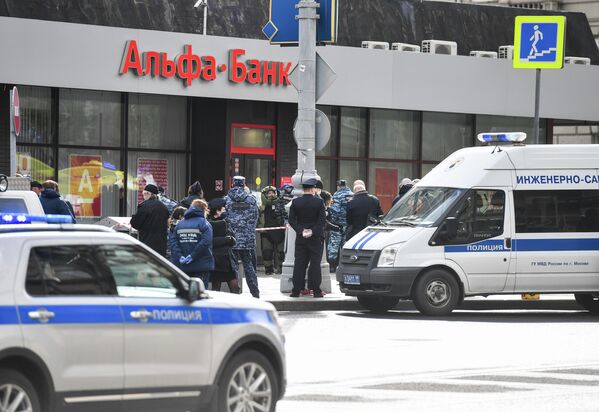 Сотрудники полиции у отделения Альфа-банка в центре Москвы, откуда поступило сообщение, что неизвестный удерживает несколько человек и угрожает взорвать отделение