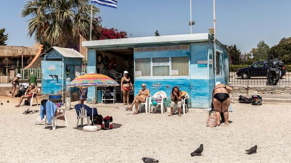 Люди на городском пляже Алимос в пригороде Афин