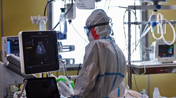 Медицинский работник возле кровати пациента в одном из отделений госпиталя COVID-19 в Центре мозга и нейротехнологий ФМБА России