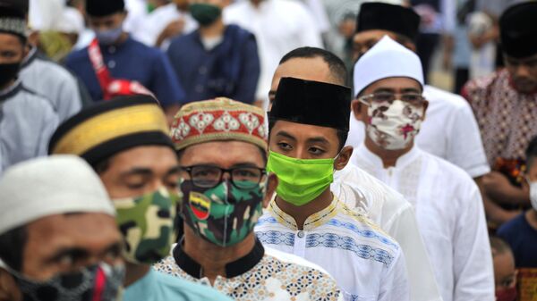 Верующие в защитных масках у мечети Аль-Машун в провинции Северная Суматра в Индонезии
