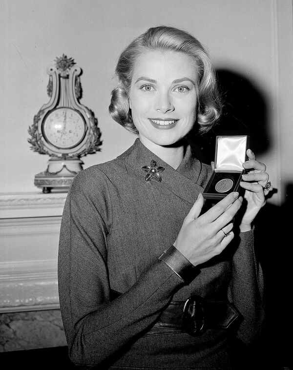 Актриса Грейс Келли с серебряной медалью, врученную ей Министерством финансов США. 30 марта 1956 года