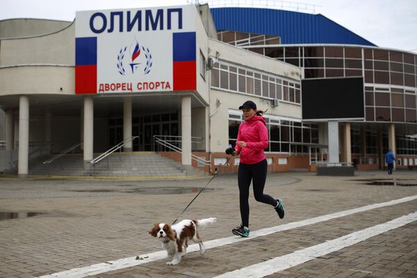 Девушка во время пробежки на улице Береговой в Краснодаре