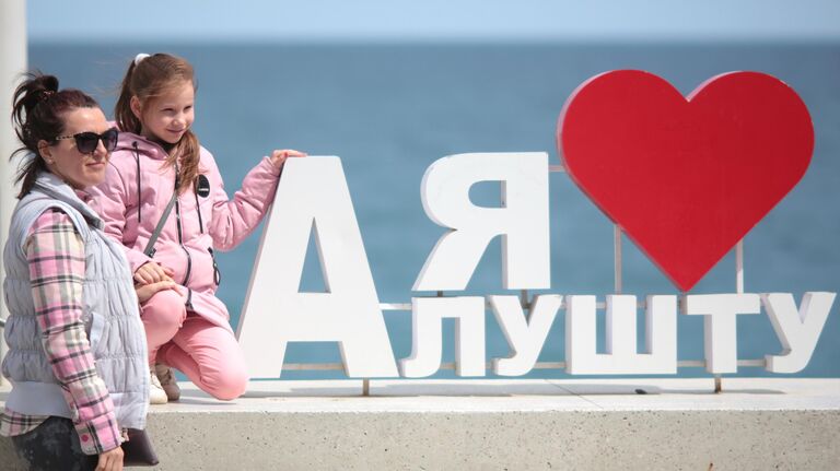 Женщина с ребенком на набережной Алушты после отмены режима самоизоляции в Крыму