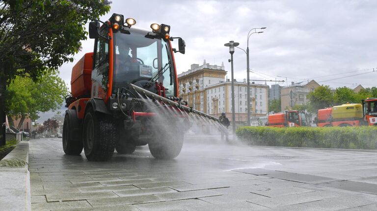 Автомобиль коммунальных служб во время дезинфекции тротуаров в Москве