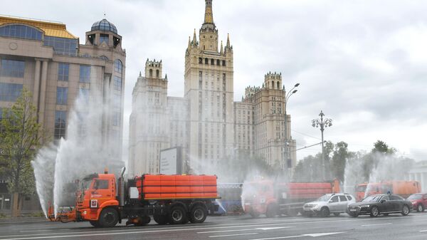 Автомобили коммунальных служб во время дезинфекции проезжей части дорог в Москве
