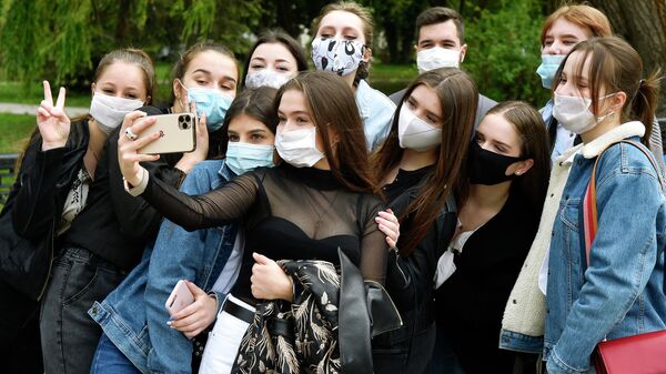 Выпускники средней школы фотографируются после празднования последнего звонка в парке Гагарина в Симферополе
