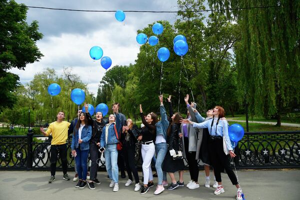 Выпускники средней школы отпускают воздушные шары после празднования последнего звонка в парке Гагарина в Симферополе